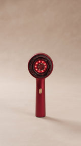 Brosse massante HairRevive rouge sur fond beige